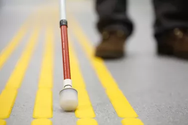 Blind pedestrian walking on tactile paving