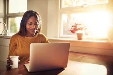 Laughing woman looking at laptop