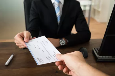 Businessman Giving Cheque To Other Person