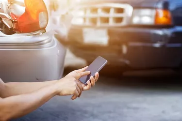 Man using smartphone at roadside after traffic accident