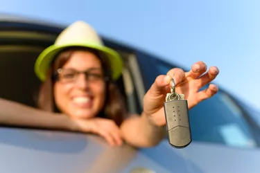 How to Buy a Repossessed Car                       Woman holding car keys