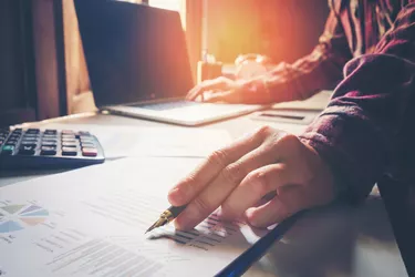 business man pointing his ideas and writing business plan at workplace,man holding pens and papers, making notes in documents, on the table