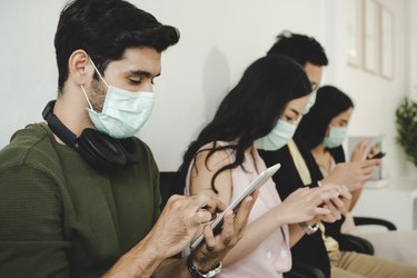 group of business people wearing protective face mask using digital mobile phone connection internet in meeting room at office, network technology, social media marketing, business startup concept