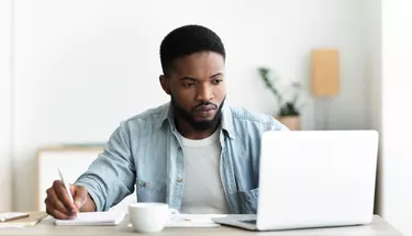 Unemployed man using laptop searching for vacancies online in internet