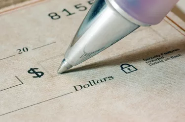Super close-up photo of a ballpoint pen, and a bank check