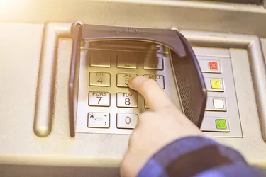 Close-up of hand entering PIN on ATM, bank machine keypad