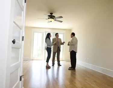 What Does "Owner Will Carry Note" Mean?Couple with realtor looking at new home