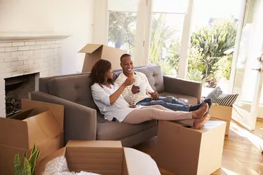 Couple On Sofa Taking A Break From Unpacking On Moving Day