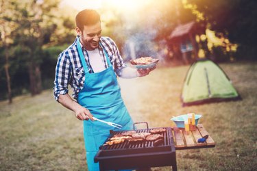 Handsome male preparing barbecue
