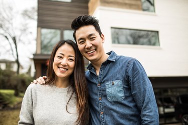 Portrait of young couple in front of new home