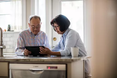 Senior couple using tablet on couch at home