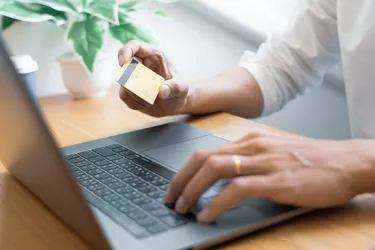 Man paying with credit card and entering security code for online shopping making a payment or purchasing goods on the internet with laptop computer, online shopping concept.