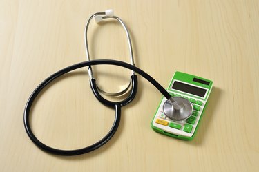 How Do I Claim Medical Hardship for Hospital Bills? Stethoscope with Calculator on Desk