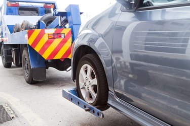 Car Repossession Laws in Michigan              Tow truck towing a broken down car on the street