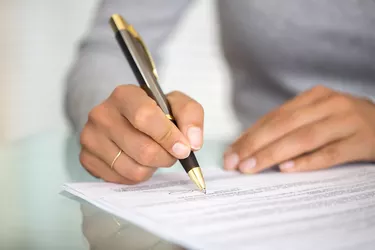 Woman at office desk signing a contract
