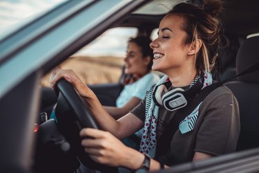 Twin sisters driving car and enjoying road trip