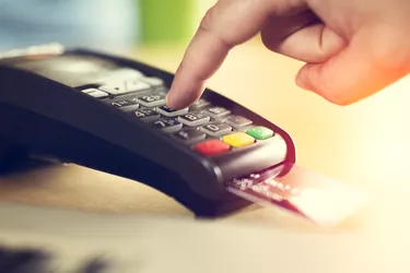 Hand with credit card swipe through terminal for sale