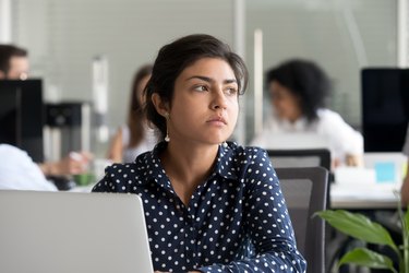 Thoughtful indian businesswoman looking away thinking of problem solution