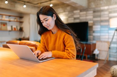 Young stylish woman using laptop at home