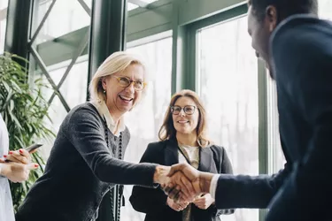 Senior businesswoman greeting colleagues during conference