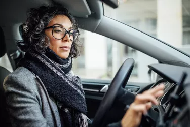 Woman behind the wheel using phone for navigation