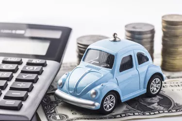 Close up blue car with calculator and coin.Selective focus in car.