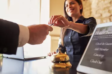 What Is a Pre-Authorization for a Settlement Credit?Guest takes room key card at check-in desk of hotel