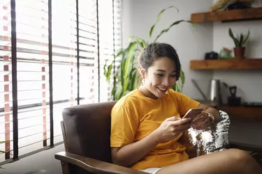 Woman using her smart phone at home