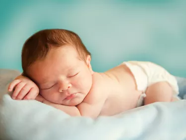 Close-up photo of sleeping newborn wearing diaper