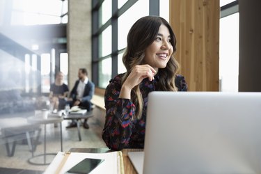Smiling businesswoman working at laptop