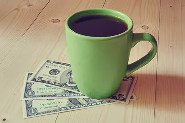 Cup of coffee on dollar bills pile