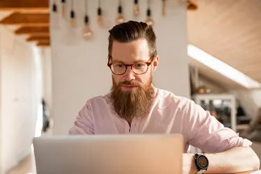 Man searching for jobs at home by his laptop