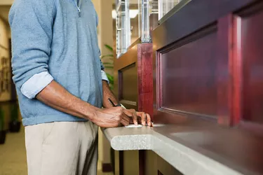 Customer writing cheque at bank counter