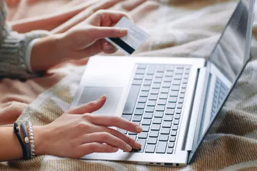 Hand with credit card on laptop. Internet payment.