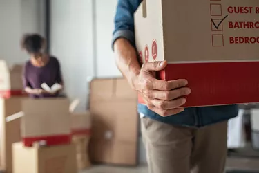 Hands holding cardboard box during relocation