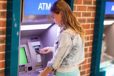 Do Credit Cards Have PIN Numbers?  Pretty brunette student withdrawing cash