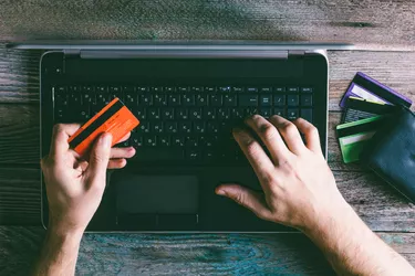 Man Hands holding credit card and using laptop