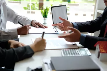 couple buying renting house signing mortgage contract agreement with realtor real estate agent.