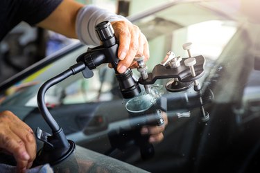 The broken car glass being repaired using professional equipment.