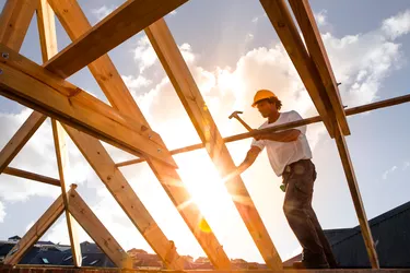 roofer worker builder working on roof structure at construction site