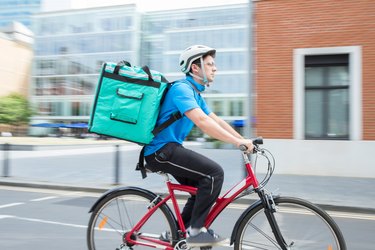 Courier On Bicycle Delivering Food In City