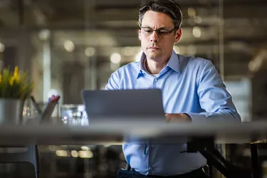 Male entrepreneur reading an e-mail on laptop in the office.