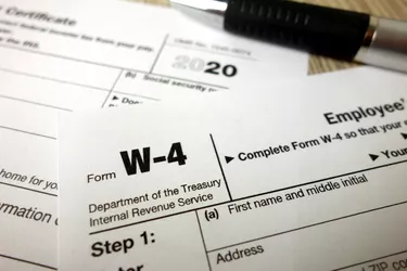 Blank W-4 form and a pen. Tax season