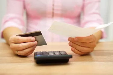 How to Add Money to an Emerald Card          woman is holding bill and credit card in hands