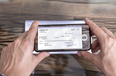 Man Taking Photo Of Cheque To Make Remote Deposit