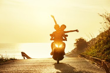 Happy couple travel motorcycle sea road