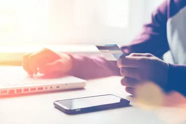 Man with bank card and laptop making online shopping