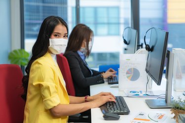 Businesswoman or office worker are working and wear mask for protect Covid-19 or coronavirus disease for New normal and social distance concept in office.