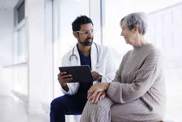 Doctor and patient in conversation, looking at digital tablet