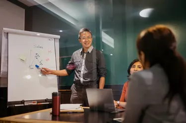 Asian businessman giving presentation in board room